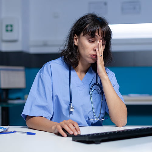 Erschöpfte Pflegekraft am Computer – Burnout.
