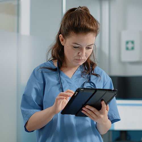 Pflegerin dokumentiert Patientendaten auf einem Tablet.